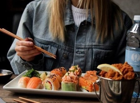 Jeune femme mangeant un plateau de divers sushis