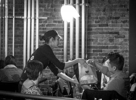 Serveuse qui donne une commande Sushi Shop au restaurant